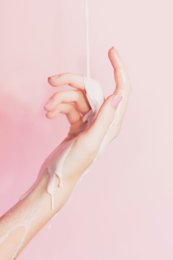 Lotion poured over a hand, as moisturised skin holds fragrance longer